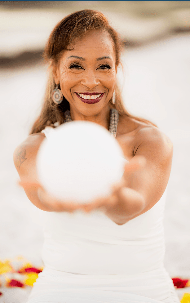 Dr. Cynthia Higgins holding a luminous orb on the beach